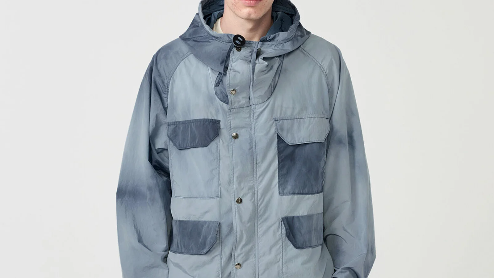 THE NORTH FACE PURPLE LABEL 마운틴 파카 정면 클로즈업 — 후드 스냅 여밈과 대형 카고 포켓 네 개가 드러나는 실루엣